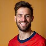 Tom smiling in a sports jersey